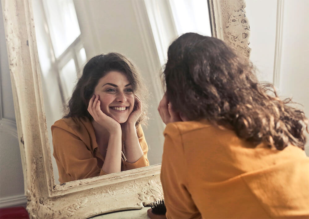 woman looking at herself in a mirror