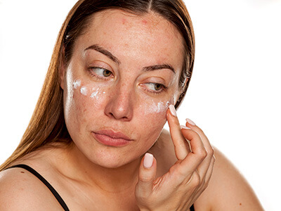 woman applying cream to her face