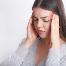 woman rubbing her temples because she has a headache